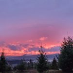 Sunrise over the mountains with clouds in pink and purple hues.