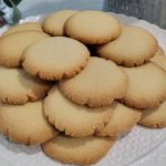 Golden butter cookies on a cake display.