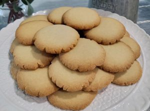 Golden butter cookies on a cake display.