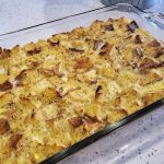 Fresh baked French Toast Casserole in a glass Pyrex baking dish on a white quartz countertop.