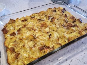 Fresh baked French Toast Casserole in a glass Pyrex baking dish on a white quartz countertop.